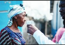 A man holds a contactless infrared thermometer close to a woman's face. The World Health Organization says Ebola virus has spread beyond the Democratic Republic of Congo, with two confirmed cases reported in neighboring Uganda. AFP VIA GETTY IMAGES