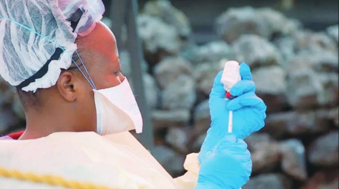 Congo A female nurse prepares a vaccine. She has inserted a needle into the bottle. Nearly 2,300 people died in the Democratic Republic of Congo's deadliest Ebola outbreak between 2018 and 2020. AFP VIA GETTY IMAGES