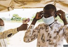 WHO: Ebola vaccine could take 9 months as toll rises A Congolese man wearing a mask holds up a contactless thermometer to a man who is putting on a mask for protection. AFP VIA GETTY IMAGES
