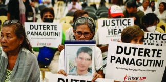 Relatives of war on drugs victims hold placards calling for justice minutes before the start of former President Rodrigo Duterte's hearing on the confirmation of charges on his alleged crimes against humanity case at the International Criminal Court, in this photo taken in Quezon City on February 23, 2026. REUTERS