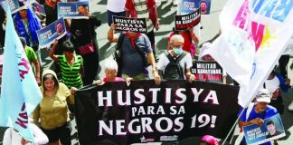 NEGROS KILLINGS. Marchers participating in the May Day protest in Manila carry a large banner demanding justice for 19 people killed in Toboso, Negros Occidental, during a military operation against New People’s Army rebels. PHOTO FROM NIÑO JESUS ORBETA