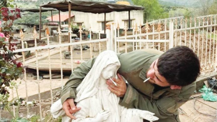 Israel This photograph shows an Israeli soldier smoking and placing another cigarette on the mouth of a statue of the Virgin Mary in southern Lebanon. The Israeli military said the photograph was taken several weeks ago. SOCIAL MEDIA