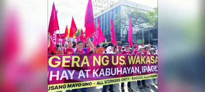 Labor Day copy_superimposed Workers took to the streets on May 1, as the National Wage Coalition led Labor Day protests calling for a P1,200 wage, job security, and urgent relief from rising prices. May 1 marked the 124th Labor Day celebration in the Philippines, yet labor groups said workers continue to grapple with the labor crisis, which is even more intensified by the Middle East war. KILUSANG MAYO UNO