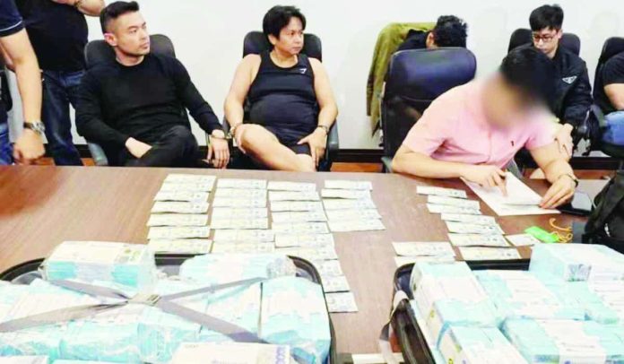 Mabanta_copy_compressed_resized Agents from the National Bureau of Investigation hold an inventory on the seized mixed marked and boodle money amounting to P75 million used to arrest social media personality Franco Mabanta (seated, left) and four others in an entrapment operation at a village in Pasig City on May 5, 2026. CONTRIBUTED PHOTO