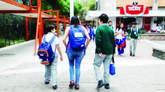 Mexico_copy_compressed_resized A mother picks up her children from an elementary school in Mexico City. She is flanked by a smaller boy, who is carrying a backpack, and a bigger boy, who is carrying a bag in his hand. Other children are walking towards them. SASHENKA GUTIERREZ/EPA/SHUTTERSTO