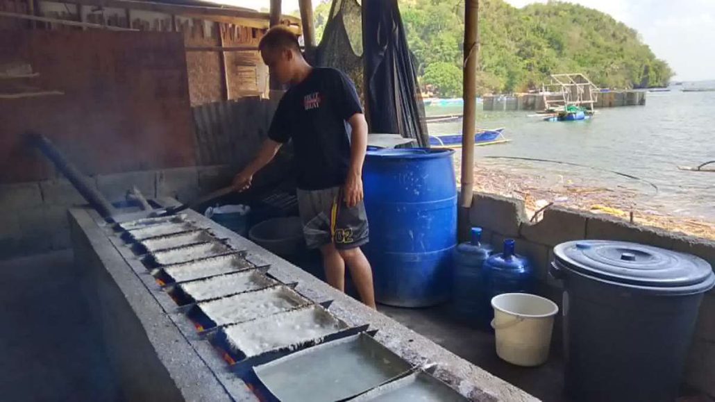 Charlie Padohinog, one of Sherley’s children, assists in the traditional cooking process of tultul salt. 