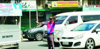 A traffic aide directs vehicles along Bonifacio Drive in Iloilo City’s City Proper district. Traffic management in the city is expected to get a boost as the Traffic and Transportation Management Office pushes to deputize barangay officials and tanods to strengthen community-based traffic enforcement and anti-illegal parking efforts. AJ PALCULLO/PN