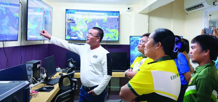 neljoy Tubungan farmers copy_compressed Department of Science and Technology personnel and Tubungan, Iloilo local government representatives observe real-time climate monitoring and forecasting systems during a benchmarking activity under the Climate Field School Program aimed at promoting climate-resilient and science-based farming practices in Iloilo Province. DOST-6