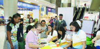 Philippine Health Insurance Corporation personnel assist workers and mallgoers during the rollout of the “YAKAP para sa Manggagawa” program at a mall-based service site in Iloilo City, facilitating on-the-spot registration, membership validation, and access to primary healthcare benefits. AJ PALCULLO/PN