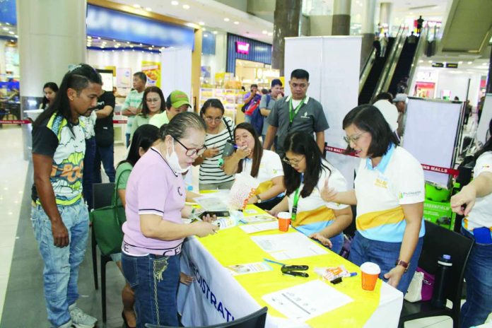 Philippine Health Insurance Corporation personnel assist workers and mallgoers during the rollout of the “YAKAP para sa Manggagawa” program at a mall-based service site in Iloilo City, facilitating on-the-spot registration, membership validation, and access to primary healthcare benefits. AJ PALCULLO/PN