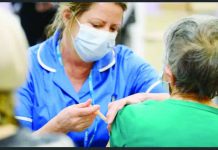 A medical professional is administering an injection to another person’s upper arm. Vaccines play a crucial role in pandemics. GETTY IMAGES