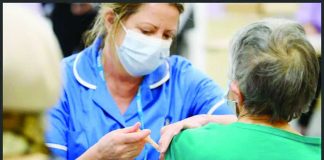A medical professional is administering an injection to another person’s upper arm. Vaccines play a crucial role in pandemics. GETTY IMAGES