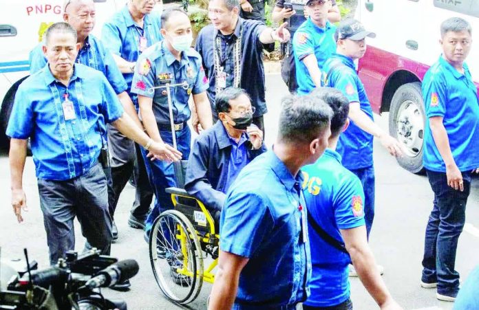 Former Department of Public Works and Highways secretary Manuel Bonoan is assisted in a wheelchair provided by court personnel upon his arrival at the Sandiganbayan in Quezon City on Tuesday, June 2, 2026. INQUIRER / GRIG C. MONTEGRANDE