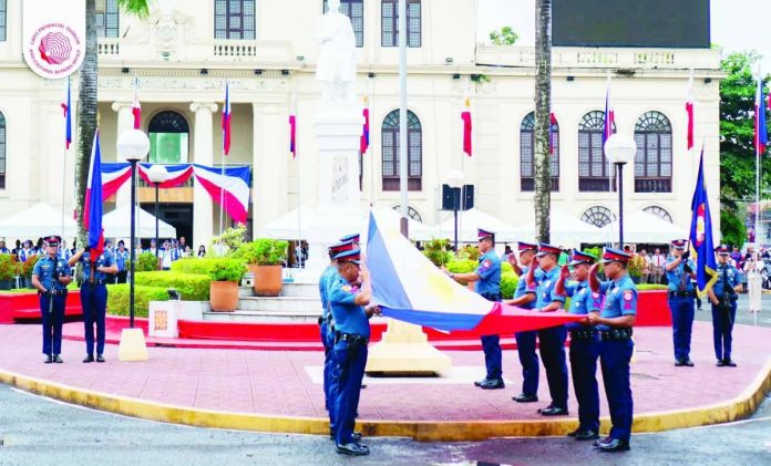Government officials, employees, and various stakeholders stand at attention during the flag-raising ceremony in front of the Capiz Provincial Capitol as part of the 128th Philippine Independence Day celebration on June 12, 2026. CAPIZ PROV’’L TOURISM AND CULTURAL AFFAIRS OFFICE