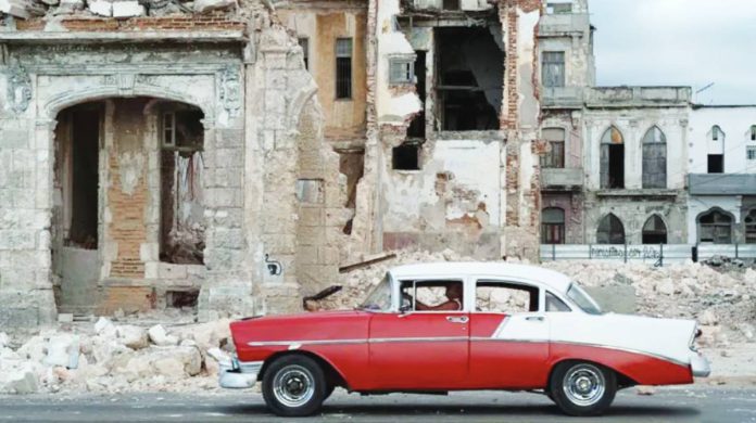 An old car drives past debris from a demolished house occupying part of the seaside promenade in the Centro Habana neighborhood in Havana, Cuba. Fuel shortages means even fewer cars are on the road in Havana. GETTY IMAGES
