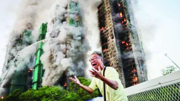 Hong_Kong.JPG_resized A man holds on both hands, shouting in agitation, as long columns of smoke billow out from Hong Kong residential blocks in the background. The blaze at the Wang Fuk Court housing complex was the deadliest the city had seen in more than 70 years. REUTERS
