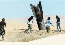 Iran, Israel pause strikes but warn of retaliation if truce breached Israeli settlers stand next to part of an Iranian ballistic missile protruding from the ground in the Israeli-occupied West Bank. REUTERS