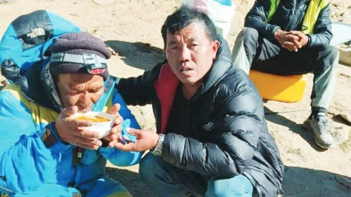 Nepal Dawa Sherpa (left), who was feared dead after going missing on Everest last week, has been found. He is shown here drinking from a bowl while being helped by a rescuer. SAGARMATHA POLLUTION CONTROL COMMITTEE