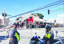 Policemen gather in front of a collapsed fast food restaurant after an 7.8 magnitude earthquake in General Santos City on June 8, 2026. Authorities continue to assess the impact of the earthquake, while residents have been advised to remain alert for possible aftershocks and comply with instructions from disaster management officials. AFP