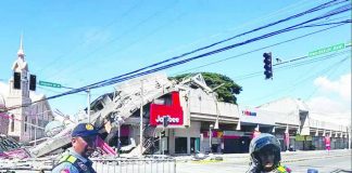 Policemen gather in front of a collapsed fast food restaurant after an 7.8 magnitude earthquake in General Santos City on June 8, 2026. Authorities continue to assess the impact of the earthquake, while residents have been advised to remain alert for possible aftershocks and comply with instructions from disaster management officials. AFP