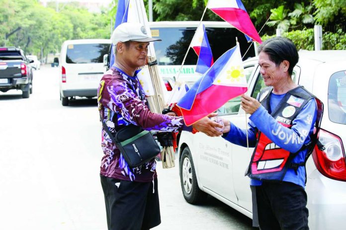 A street vendor sells Philippine flags of various sizes along J.W. Diokno Boulevard in Pasay City, Metro Manila, ahead of the country’s 128th Independence Day celebration this June 12. The flags are priced from P55 to P120, depending on the size. The Philippine National Police has placed thousands of officers on heightened alert across Metro Manila as part of an intensified nationwide security operation for the Independence Day celebration. PNA