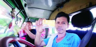 A public utility jeepney driver shows his diesel fuel discount card as he stops to refuel at a gas station in Quimpo Boulevard in Davao City. His wife, who serves as his conductor, is all smiles about the P10-per-liter discount they received through the government fuel subsidy program. She says life is hard so she has to work, too. PNA