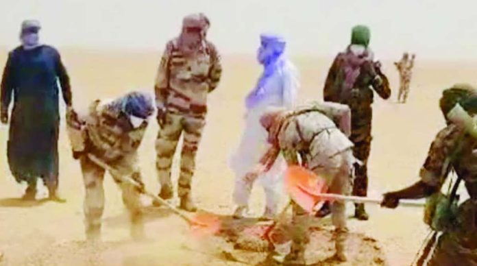 Sahara_copy_compressed_resized People, including several in military-style uniforms, use shovels to dig in a sandy desert area, with dust rising around them. AGADEZ GOVERNORATE/FACEBOOK