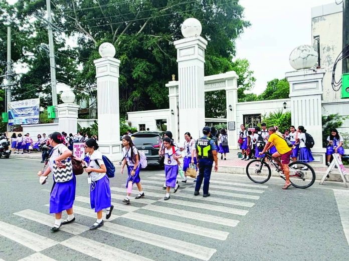 front_pic_compressed_resized Mayor Raisa Treñas has ordered the Schools Division of Iloilo City, the local police and concerned offices to double security measures in all schools in the city following a deadly shooting incident inside a public high school in Tacloban City. “Indi kita maghulat nga may matabo antes kita maghulag,” Treñas emphasized. Photo shows a police officer managing traffic and guiding students safely across the street outside Iloilo National High School in La Paz district after classes on Monday afternoon, June 22. MAI LADIAO/PN