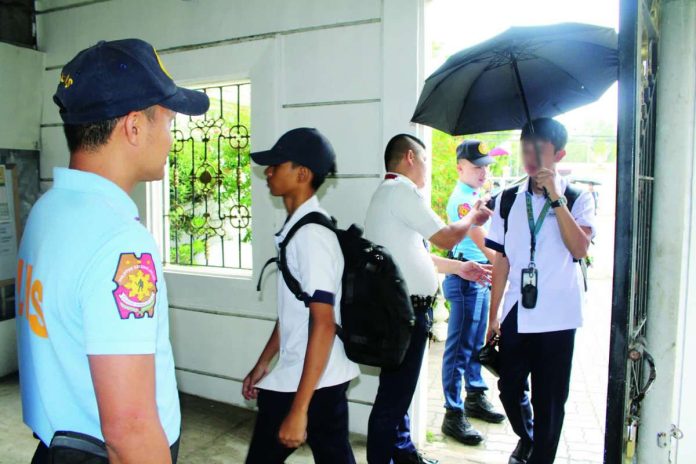 Police officers from Iloilo City Police Station 2 assist a campus security guard in inspecting the bags and belongings of students and visitors before entering the premises of Iloilo National High School in La Paz district on Tuesday, June 23. Beyond physical security measures, the Department of Education Region 6 says they are placing renewed focus on addressing bullying, which school authorities believe must be tackled proactively to prevent conflicts among learners from escalating. AJ PALCULLO/PN