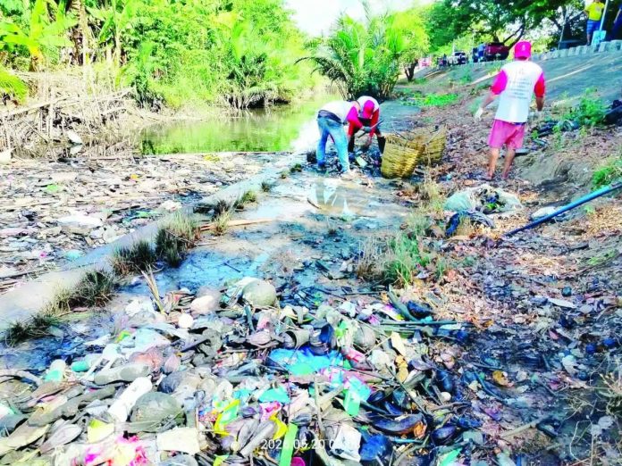RIVER OF TRASH. Workers of the Iloilo City Government remove piles of garbage from a heavily polluted section of a waterway during the “Oplan Kontra Baha” cleanup campaign. City officials said 74 tons of waste were collected in just two weeks, highlighting years of accumulated garbage that contribute to flooding and environmental degradation in the city. GSO PHOTO