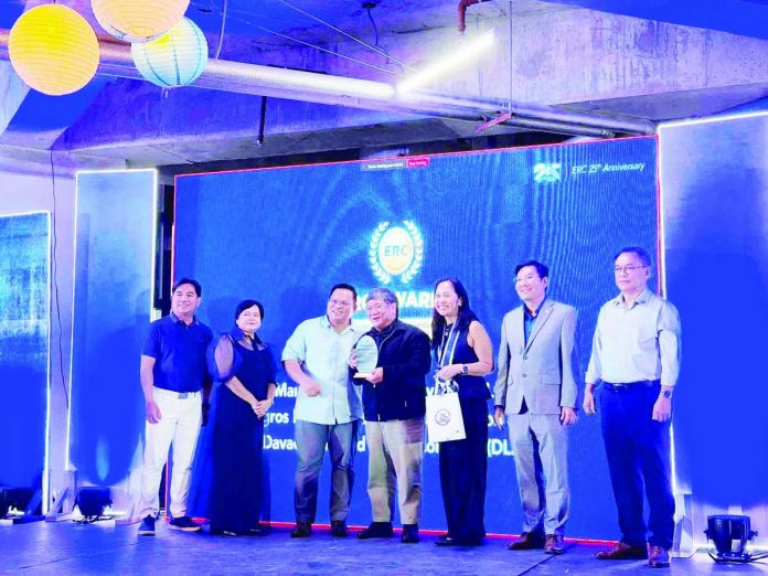 secondary_negros_power1_compressed_resized Negros Power president and chief executive officer Roel Castro (center) accepts the plaque of recognition from Energy Regulatory Commission chairperson Atty. Francis Saturnino Juan (third from left) and Energy Secretary Sharon Garin (fourth from left) on June 26, 2026, for the utility's outstanding role in advancing the country's clean energy transition.