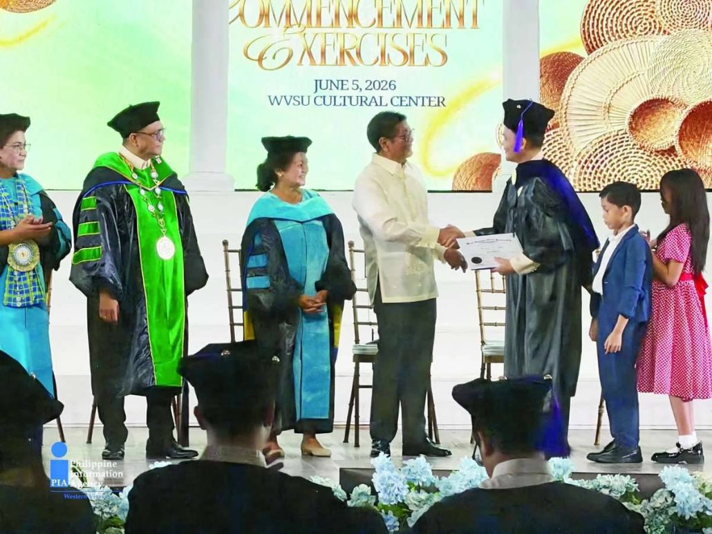 Photo shows President Marcos Jr. shaking hands with a graduate during the investiture of the academic hood and awarding of diplomas. Also on stage are First Lady Louise Araneta-Marcos and university officials. PIA WESTERN VISAYAS PHOTO