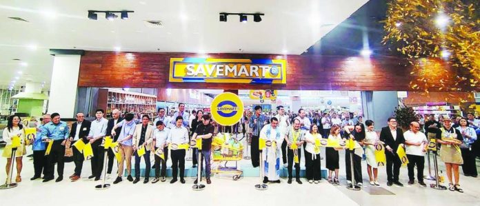 Stakeholders from SM Savemart and Vista Mall, alongside guests, lead the ceremonial ribbon-cutting to mark the official opening of Savemart at Vista Mall Iloilo.