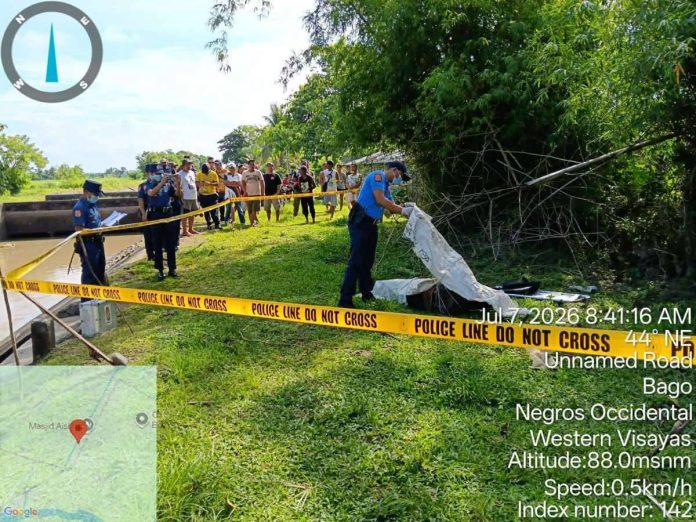 Bago_dead_body_compressed_resized Police investigate the death of a 39-year-old vendor whose body was found submerged in an irrigation canal in Purok Narra, Barangay Malingin, Bago City, on Tuesday, July 7. Authorities are pursuing leads to identify the suspect or suspects behind the killing. PRO-NIR PHOTO