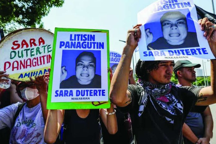 Defense_ready_copy_compressed_resized Protesters against Vice President Sara Duterte-Carpio carry posters bearing her photo during a rally near the Senate in Pasay City. AP