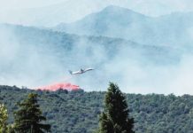 A firefighting plane drops fire retardant as it flies over a wildfire in Ille-sur-Tet near Perpignan in southern France. Thousands of people have been evacuated from towns and villages in the French Pyrenees region due to a wildfire. REUTERS