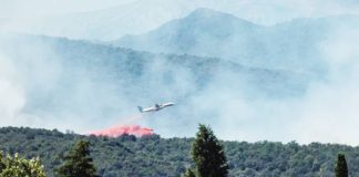 A firefighting plane drops fire retardant as it flies over a wildfire in Ille-sur-Tet near Perpignan in southern France. Thousands of people have been evacuated from towns and villages in the French Pyrenees region due to a wildfire. REUTERS