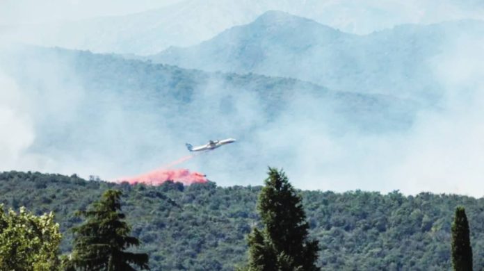 France A firefighting plane drops fire retardant as it flies over a wildfire in Ille-sur-Tet near Perpignan in southern France. Thousands of people have been evacuated from towns and villages in the French Pyrenees region due to a wildfire. REUTERS