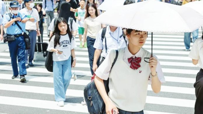 Japan Japanese people walk over a crossroad on a hot summer day. GETTY IMAGES