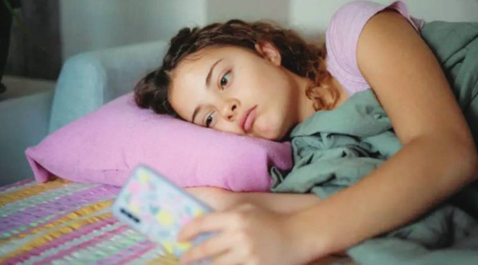Meta A young woman with a glum expression scrolls on her smartphone. GETTY IMAGES