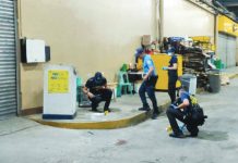 Police investigators process the scene at the storage area of GT Town Mall in Barangay Ungka II, Pavia, Iloilo, on Friday, July 31, 2026. A security guard stationed at the mall shot one of two suspects in self-defense after being assaulted and threatened.