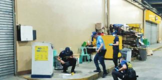 Police investigators process the scene at the storage area of GT Town Mall in Barangay Ungka II, Pavia, Iloilo, on Friday, July 31, 2026. A security guard stationed at the mall shot one of two suspects in self-defense after being assaulted and threatened.