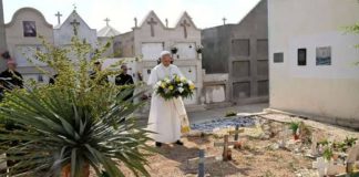 Holding flowers at a cemetery in the island of Lampedusa in Italy, Pope Leo XIV prays at the graves of migrants who had died while making the journey from Africa to Italy. REUTERS