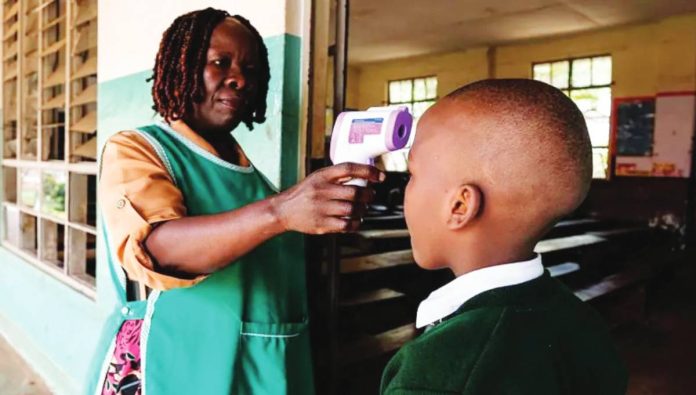 Uganda A woman uses a thermometer gun to check the temperature of a school pupil. Uganda introduced tightened screening and other protocols as soon as the Ebola outbreak was declared in May. GETTY IMAGES