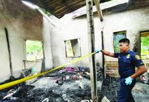 A fire officer from the Bureau of Fire Protection-Anilao inspects the gutted house in Barangay Dangulaan, Anilao, Iloilo. The blaze claimed the life of an 84-year-old woman on Wednesday night, July 22, 2026. PHOTO COURTESY OF BFP-ANILAO