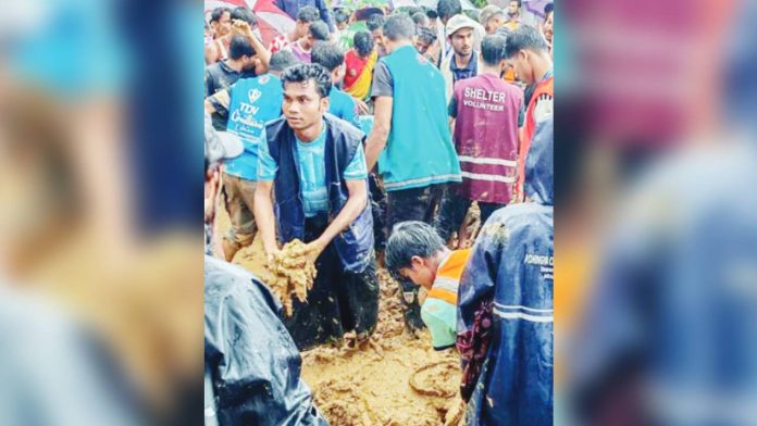 bangladesh A large group of volunteers and aid workers stand in deep mud during heavy rain, working together at the site of a landslide by a school at a refugee camp in Cox’s Bazar, Bangladesh. AFP VIA GETTY IMAGES