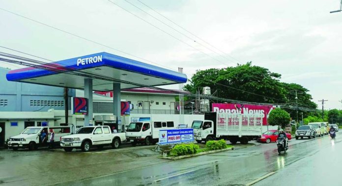 Vehicles line up at the Petron gasoline station in Barangay Mali-ao, Pavia, Iloilo on Monday afternoon, July 20, to fill up their tanks ahead of the scheduled big-time oil price hike set to take effect today, July 21. The Department of Energy announced maximum price increases starting today of up to P3.65 per liter for gasoline, P10.68 per liter for diesel, and P11.77 per liter for kerosene. AJ PALCULLO/PN