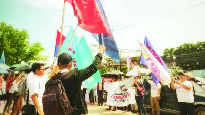 mai_SONA_peaceful_copy_compressed_resized PEACEFUL PROTEST. Demonstrators wave flags and raise clenched fists during a peaceful assembly in Iloilo City held alongside President Ferdinand Marcos Jr.’s fifth State of the Nation Address on July 27. Police Regional Office 6 reported no major untoward incidents across Western Visayas, crediting comprehensive security preparations, heightened police visibility and sustained intelligence monitoring. AJ PALCULLO/PN