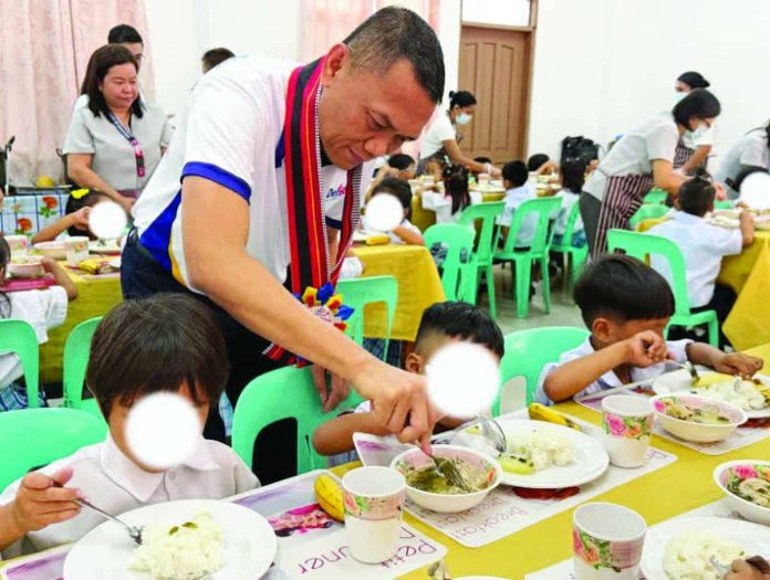 neljoy_feeding_copy_compressed_resized Department of Education – Region 6 director Dr. Cristito Eco serves nutritious meals to young learners during the launch of “Healthy Learners, Stronger Champions: School-Based Feeding Program” in Roxas City on July 8. DEPED-WESTERN VISAYAS