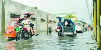Motorists, cyclists and tricycle drivers carefully make their way through floodwaters along a flooded street in Iloilo City after recent heavy rains, underscoring the continuing risk of urban flooding and the need for residents to remain vigilant against waterborne diseases such as leptospirosis. AJ PALCULLO/PN